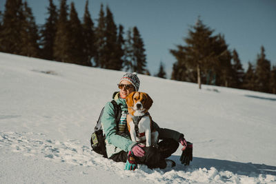 Boy playing on snow field against trees during winter