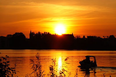 Scenic view of lake against orange sky