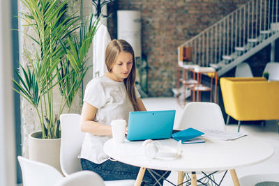 Woman sitting on table at home