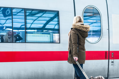 Rear view of woman standing in bus