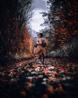 People walking on autumn leaves in park