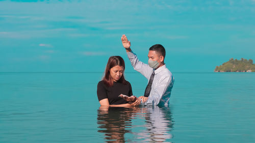 Portrait of a woman being baptized by a priest from the adventist church