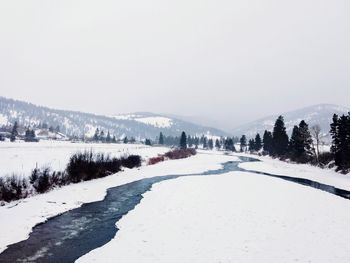 Snow covered landscape against clear sky