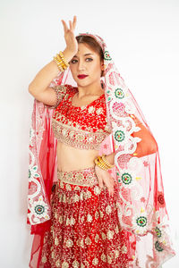 Portrait of young woman standing against white background