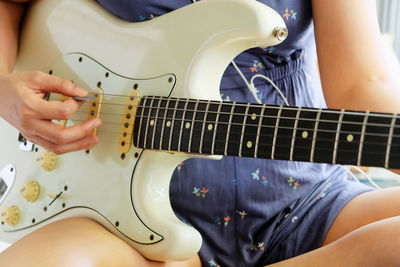 Midsection of person playing guitar