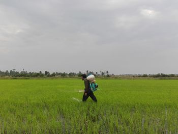 Man standing on field against sky