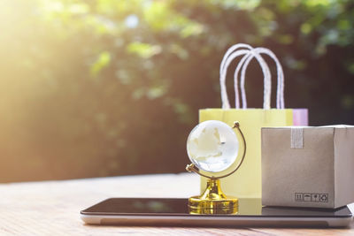 Close-up of globe with gifts and smart phone on table