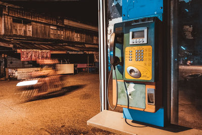 Close-up of pay phone on street at night