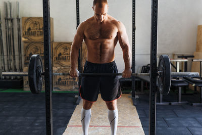 Shirtless man exercising in gym