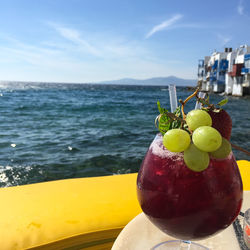 Close-up of fruits on table at sea shore against sky