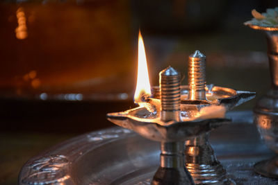 Close-up of lit candles in temple against building