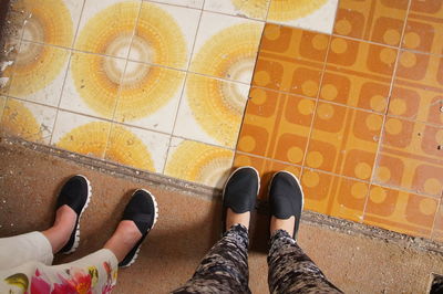 Low section of people standing on tiled floor
