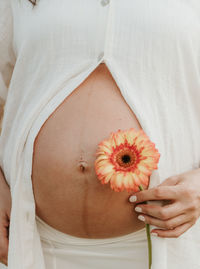 Midsection of woman holding flower