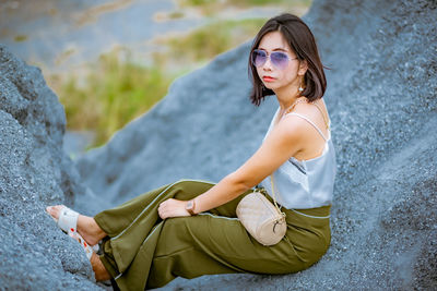 Young woman sitting on rock