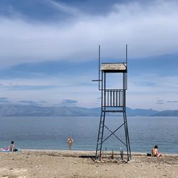 People on beach by sea against sky