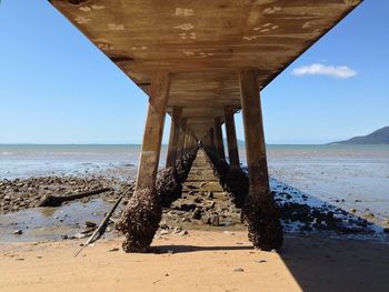 View of pier on beach against sky