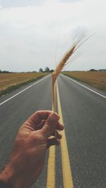 Close-up of man holding umbrella on road