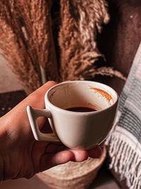 Close-up of hand holding coffee cup
