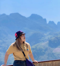 Young woman looking at mountains against sky