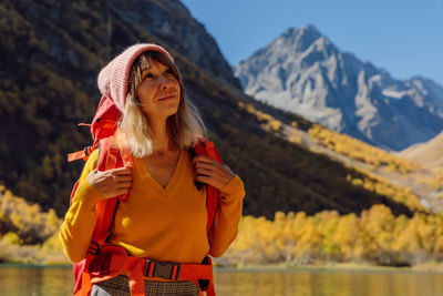 Young woman standing against mountain