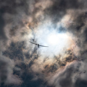 Low angle view of silhouette airplane flying in sky