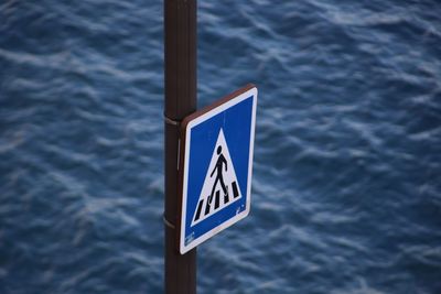 Close-up of pedestrian crossing sign against wall