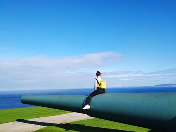 Man on sea against blue sky