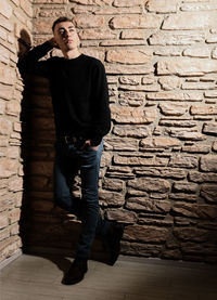 Full length of man standing against wall