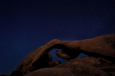 Low angle view of rock formation against sky at night