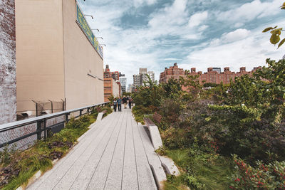 Footpath amidst buildings against sky