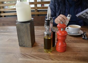 Person with condiments on table