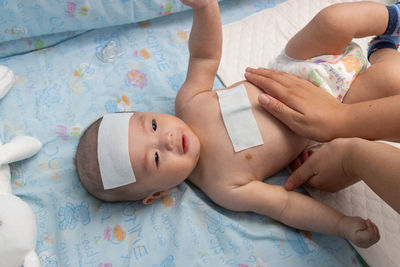 High angle view of baby lying on bed