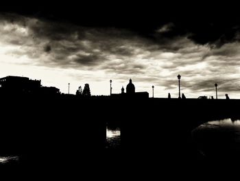 Silhouette of building against cloudy sky