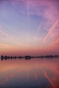 Scenic view of lake against romantic sky at sunset