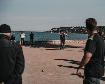 Rear view of people looking at sea against sky