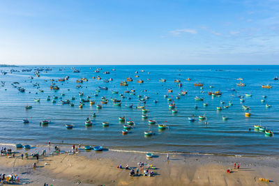 High angle view of people on beach against blue sky