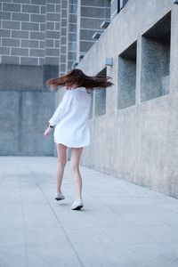 Full length of woman walking against building