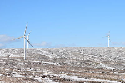 Low angle view of windmill against clear blue sky