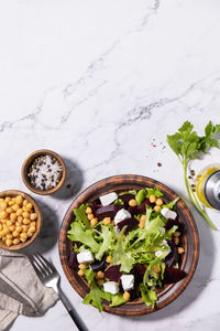 Healthy spring salad beet with spinach, cheese feta and chickpeas on a marble tabletop. 