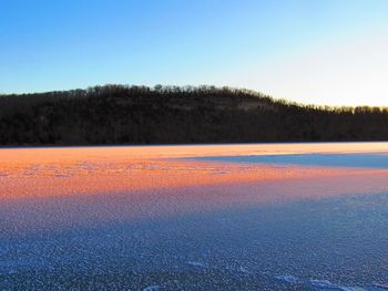 Scenic view of land against clear sky during winter