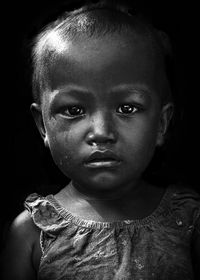 Close-up portrait of girl against black background