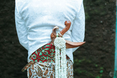 Rear view of a man holding white umbrella