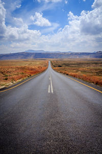 Empty road along countryside landscape