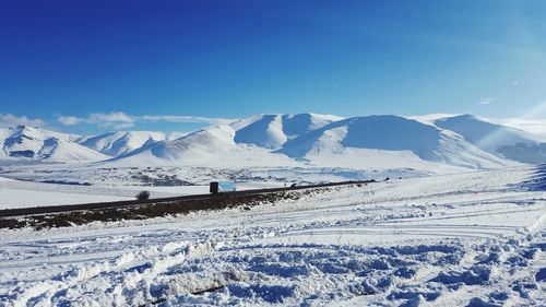 Scenic view of snowcapped mountains against blue sky