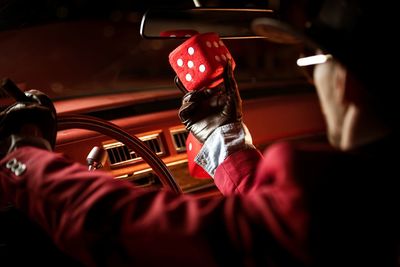 Man holding dice in car at night