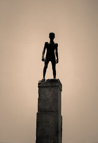 Low angle view of silhouette statue against sky