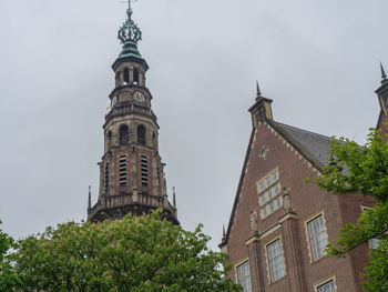 Low angle view of trees and building against sky