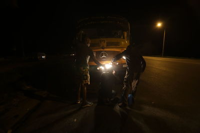 Man walking on illuminated road at night