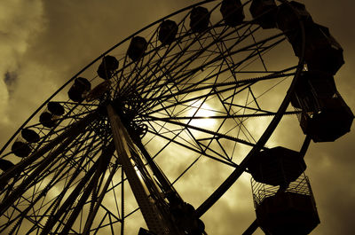 Low angle view of silhouette ferris wheel against sky