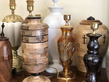 Close-up of electric lamp on table against wall